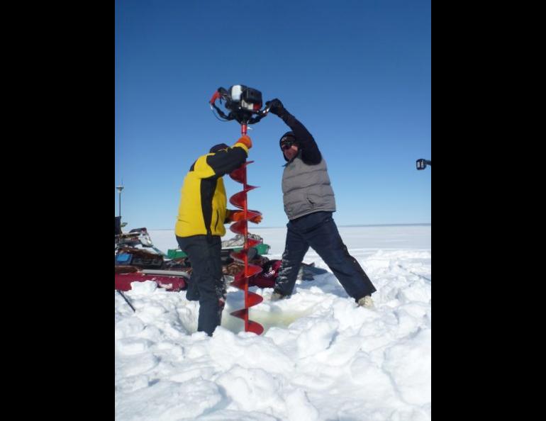 Chris Arp and Ben Jones drill into the ice of a shallow lake on Alaska’s North Slope. Photo by Guido Grosse, Alfred Wegener Institute.