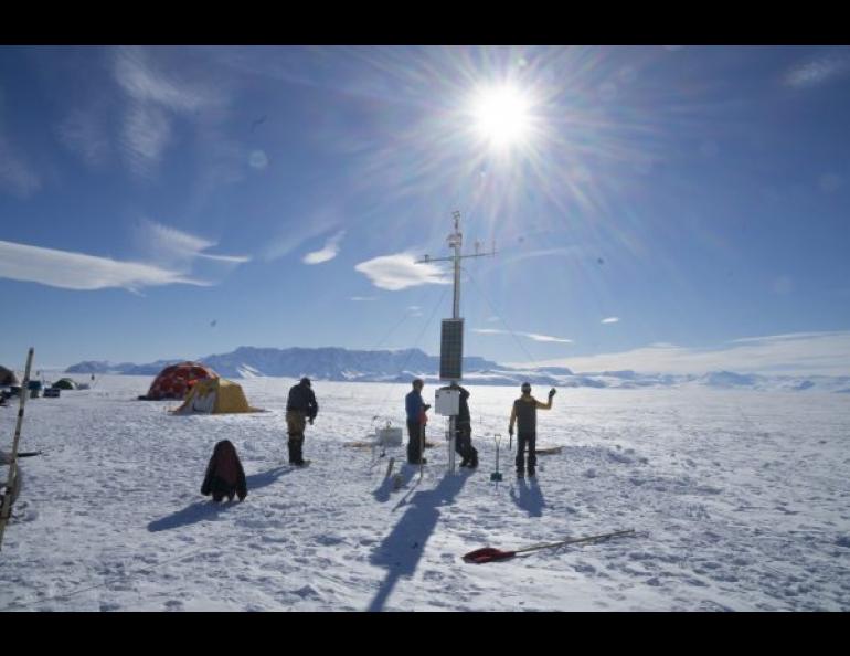 A team works at an Automated Meteorology-Ice-Geophysics Observing System II station in Antarctica. Photo by Martin Truffer.