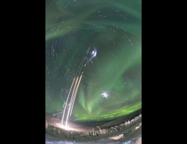 This composite photograph shows four NASA sounding rocket launches from Poker Flat Research Range on the morning of Jan. 26, 2015. A vapor released by one of the rockets is visible as small white clouds. The green beam of a lidar system is visible in the upper left. Photo by J. Adkins, NASA.