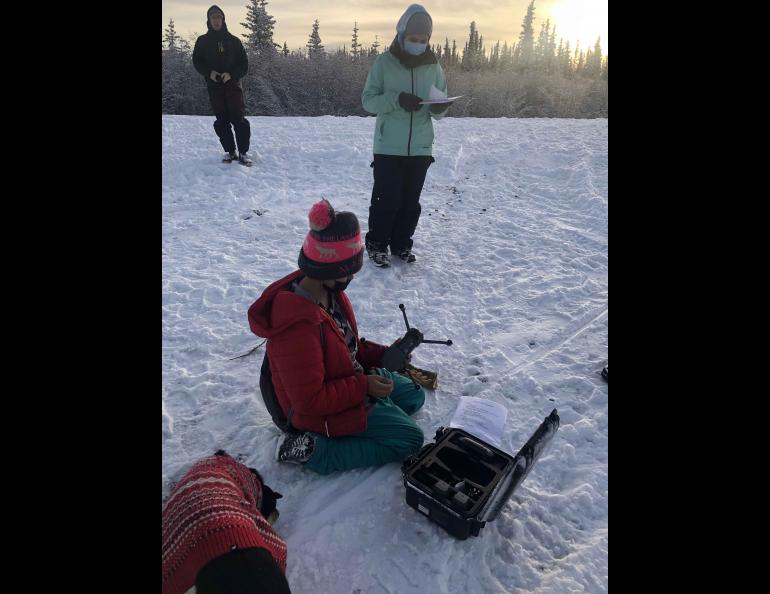 Chris Arp, a hydrologist at the UAF Water and Environmental Research Center and the lead for Fresh Eyes on Ice, watches as students from the John Fredson School in Venetie, Alaska, prepare a drone for flight. Photo by Terri Mynatt