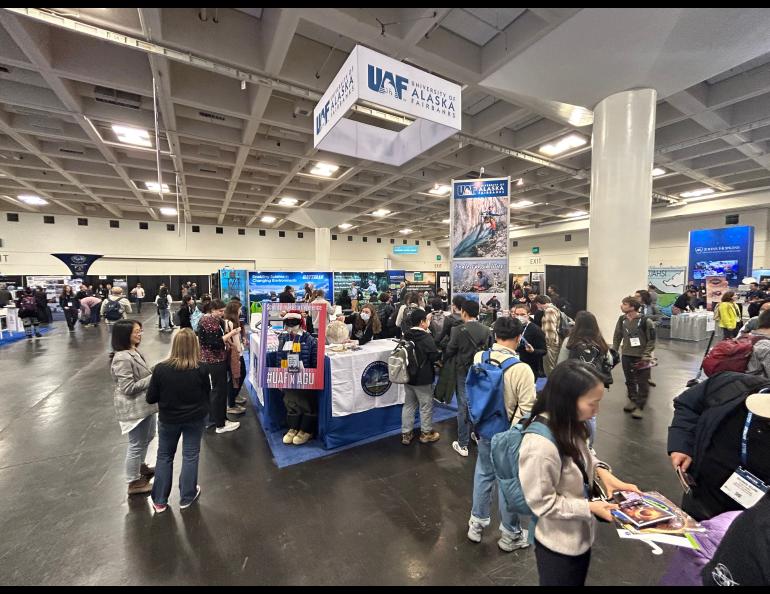 Visitors gather at the University of Alaska Fairbanks exhibitor booth at the AGU Fall Meeting 2022 in Chicago, IL. UAF GI Photo by Rod Boyce.