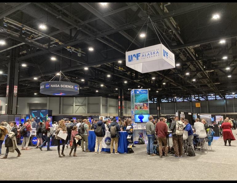 Visitors gather at the University of Alaska Fairbanks exhibitor booth at the AGU Fall Meeting 2022 in Chicago, IL. UAF GI Photo by Kelly Eagan.