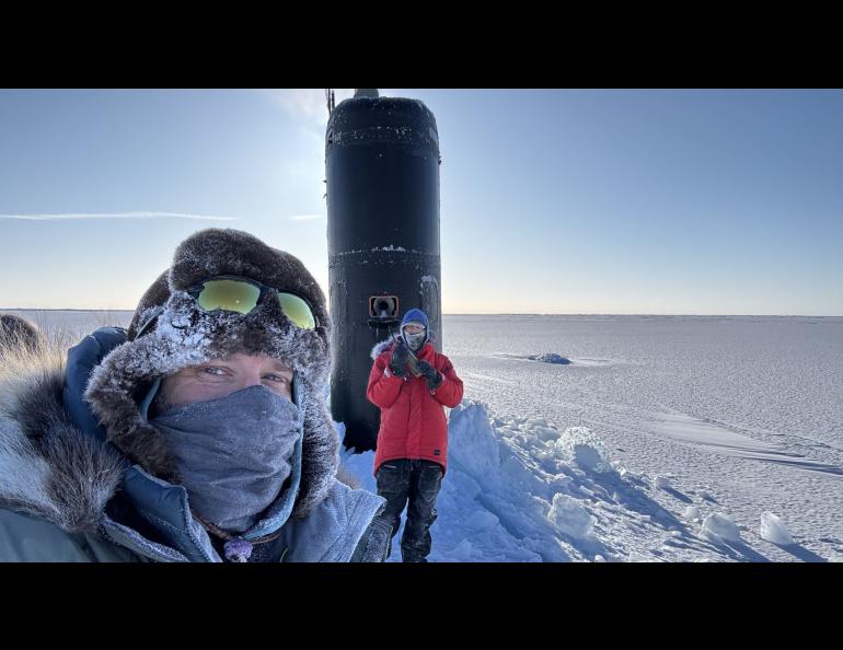 Research professor Andy Mahoney of the University of Alaska Fairbanks Geophysical Institute, left, stands near the USS Hampton’s sail during Operation Ice Camp in March 2024. A civilian employee with the Navy’s Arctic Submarine Lab stands in front of the sail. Photo courtesy of Andy Mahoney