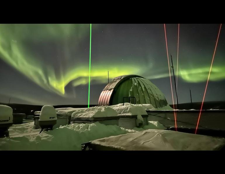 Four laser beams rise from the Lidar Research Lab at Poker Flat Research Range. The three yellow beams are the sodium resonance wind-temperature lidar and the green beam is the Rayleigh density temperature lidar. Photo by Skylar Sellers