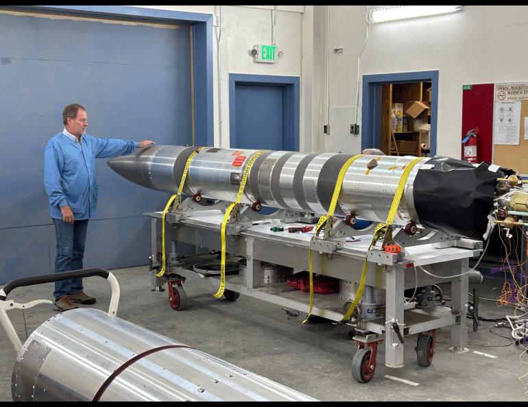 Geoff Reeves of Los Alamos National Laboratory stands in the Poker Flat Research Range payload assembly area in November 2023 with the upper portion of the four-stage NASA sounding rocket that will carry his Beam-PIE science instruments. Photo by Rod Boyce
