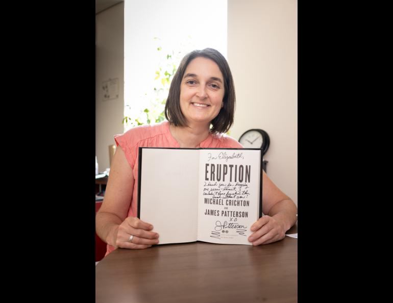  Elisabeth Nadin holds her signed copy of “Eruption.” She assisted author James Patterson with information about volcanoes. Photo by Brian Whitten