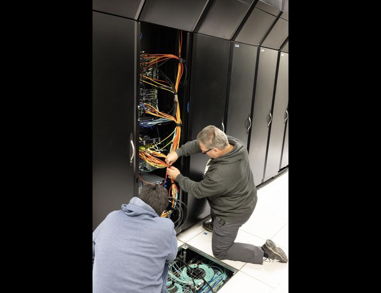 Kevin Galloway, left, and Mike Steinhauer of the Geophysical Institute’s Research Computing Systems unit attach cabling in August 2024 for the final and largest GPU node to be installed. Photo by LJ Evans