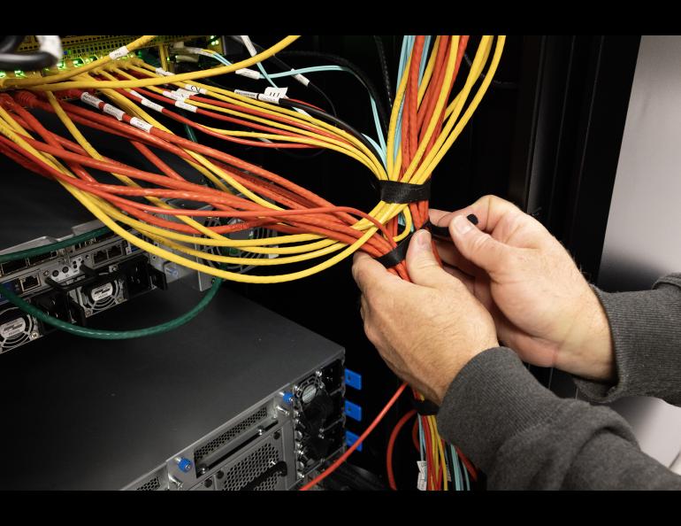 Mike Steinhauer of the UAF Geophysical Institute Research Computing Systems bundles cabling in August 2024 as the final and largest GPU node is installed in Chinook. Photo by LJ Evans