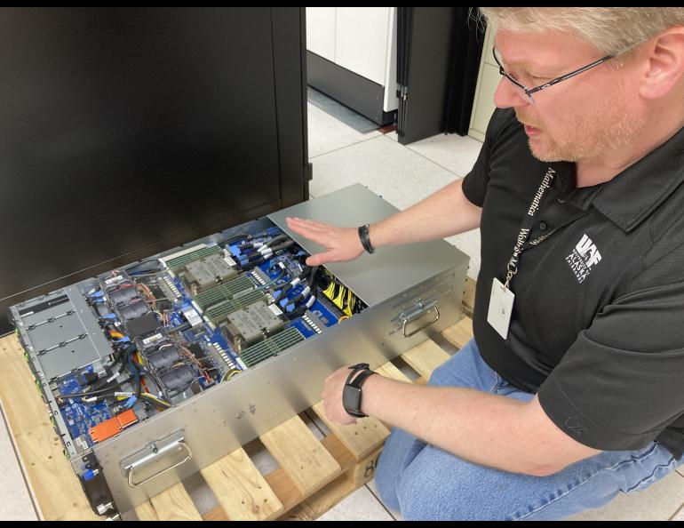 Liam Forbes, manager of Research Computing Systems at the UAF Geophysical Institute, points out some of the features in the final and largest GPU node to be installed in Chinook. The node weighs 91 kilograms, or about 200 pounds. Photo by LJ Evans