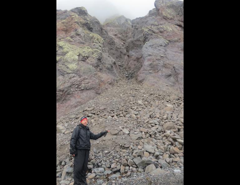 Ned Rozell pauses at the site of a rock avalanche on St. Matthew Island in the Bering Sea during a 2012 visit. Photo by Rich Kleinleder.