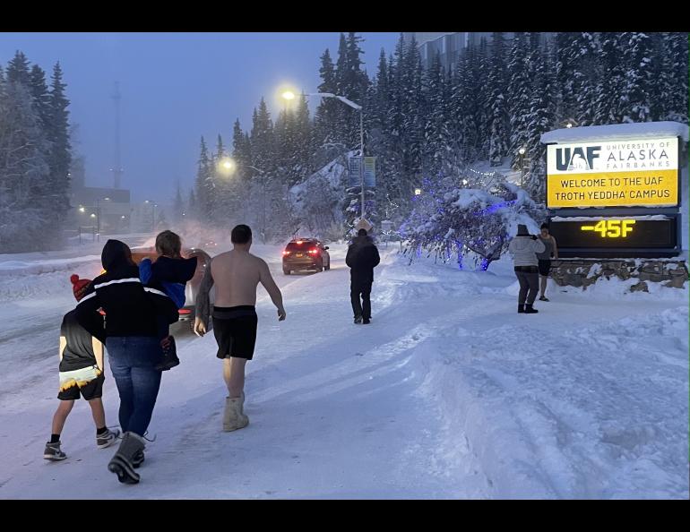 Fairbanks residents engage in a favorite cold-weather activity of taking photographs of themselves in front of the University of Alaska Fairbanks time-and-temperature sign on the morning of Jan. 27, 2024. Photo by Ned Rozell.