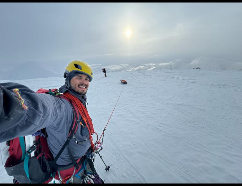 Roger Jaramillo walks on crampons while roped to a sled and his partner Matthew Crisafi-Lurtsema. The pair climbed Denali and sampled microplastics along their route in June, 2024. Photo by Roger Jaramillo.