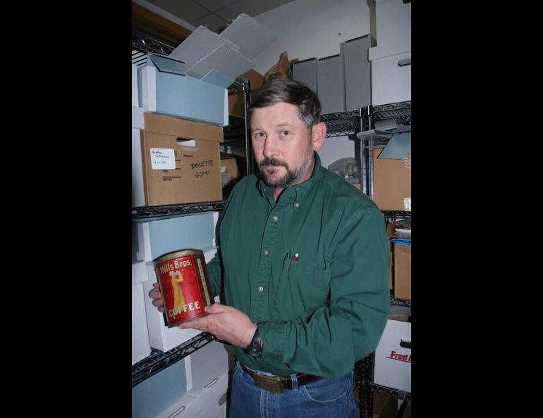  Bureau of Land Management archaeologist Steve Lanford with a Hills Bros. coffee can. BLM photo by Craig McCaa. 