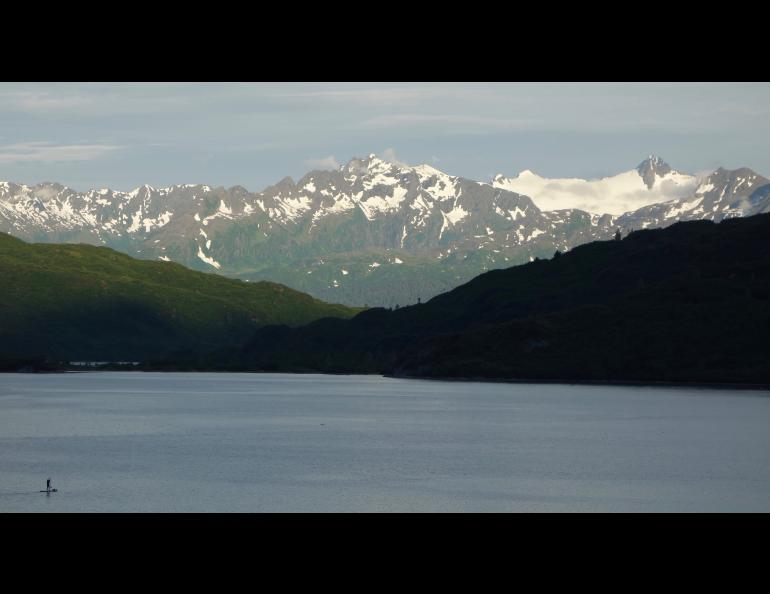 A paddle-boarder on Shoup Bay, Alaska, which is home to a few slugs. Photo by Ned Rozell.