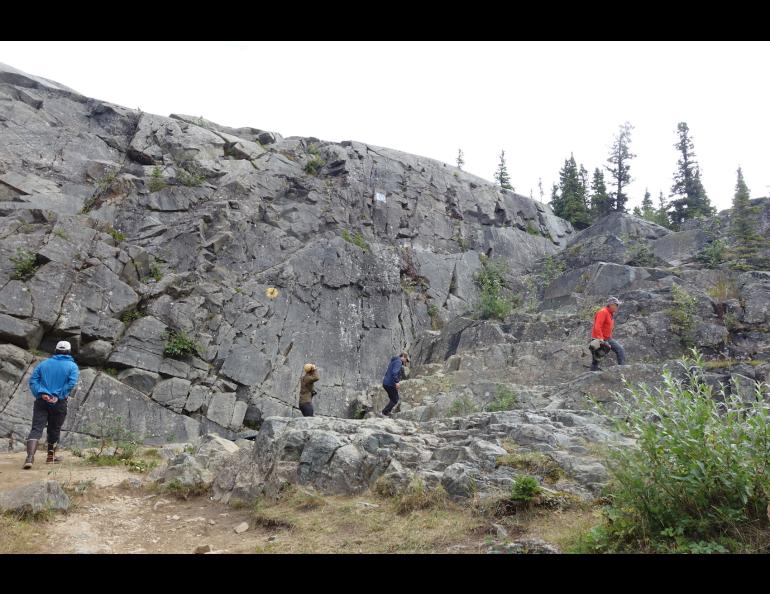 Scientists scale a rock face south of Delta Junction that was scoured bare by floodwaters from the failure of a glacial ice dam hundreds of years ago. Photo by Ned Rozell.