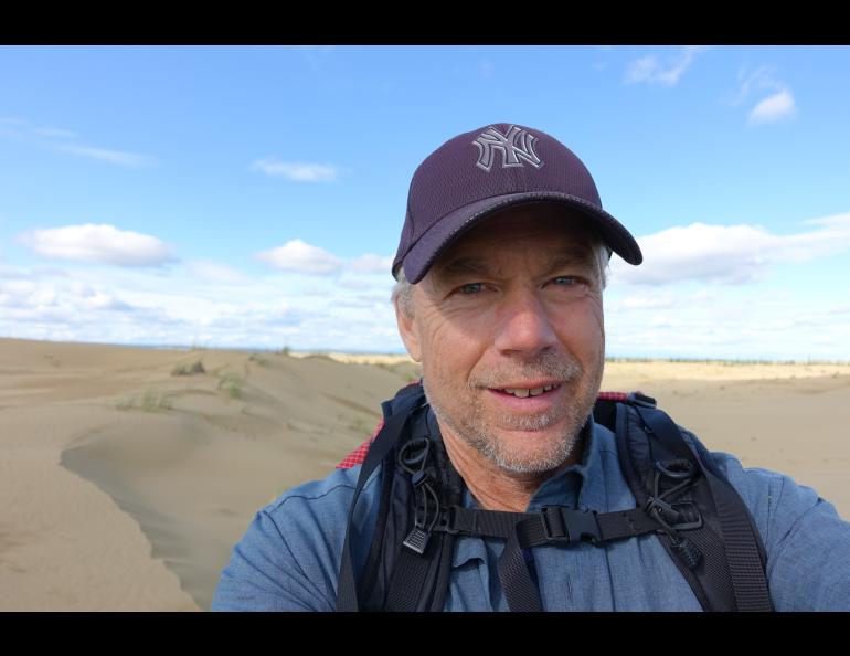 Ned Rozell hikes a sandy ridge at western Alaska’s Nogahabara Dunes in summer 2024. Photo by Ned Rozell.