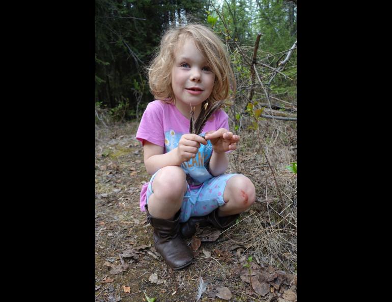 Rose Bulger, 6, holds grouse feathers she found during a family science expedition on the UAF campus. Photo by Ned Rozell.