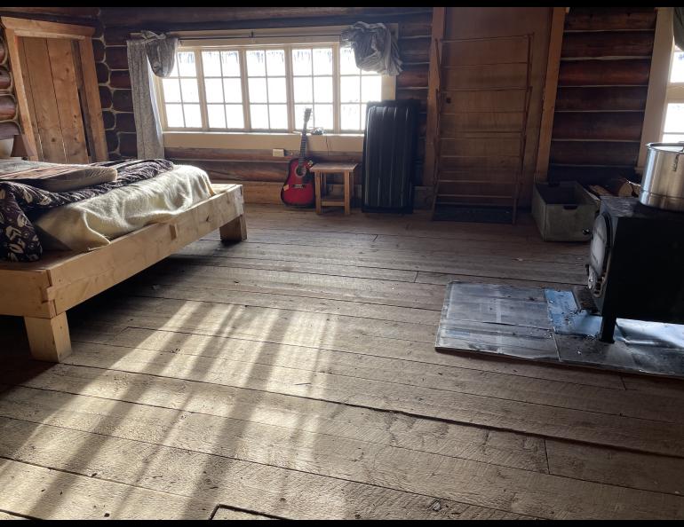 Sun shines on an interior floor of Tolovana Roadhouse, a “hospitality stop” in the 2025 Iditarod sled dog race. Photo by Ned Rozell.