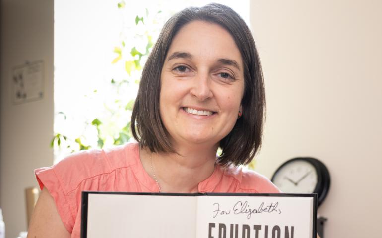  Elisabeth Nadin holds her signed copy of “Eruption.” She assisted author James Patterson with information about volcanoes. Photo by Brian Whitten