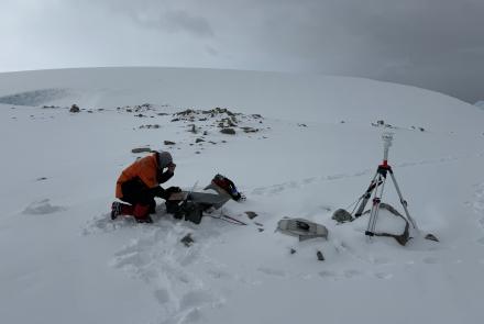 A field engineer of the Wilson Alaska Technical Center at the UAF Geophysical Institute services a portable infrasound monitoring station near Palmer Station, Antarctica. Photo courtesy of the Wilson Alaska Technical Center.