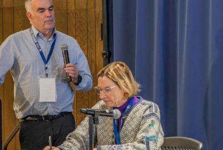 Mark Myers, commissioner of the U.S. Arctic Research Commission, leads a discussion on the potential of geologic hydrogen at a conference in Fairbanks recently. Alaska State Senator Cathy Giessel takes notes. Photo by Eric Marshall.