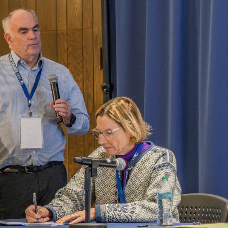 Mark Myers, commissioner of the U.S. Arctic Research Commission, leads a discussion on the potential of geologic hydrogen at a conference in Fairbanks recently. Alaska State Senator Cathy Giessel takes notes. Photo by Eric Marshall.